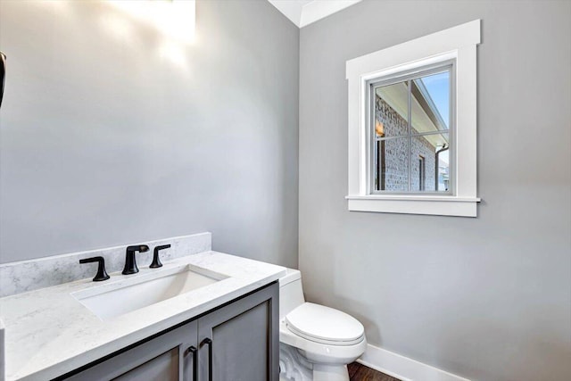 bathroom featuring wood-type flooring, toilet, and vanity