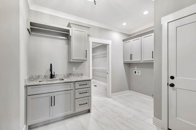 interior space with washer hookup, indoor wet bar, crown molding, and cabinets