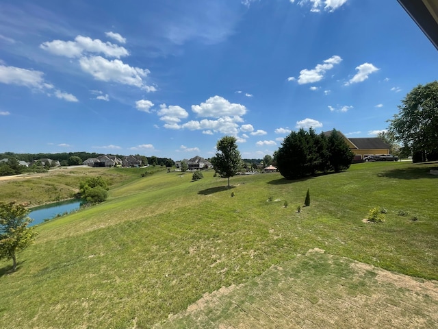 view of community featuring a water view and a yard