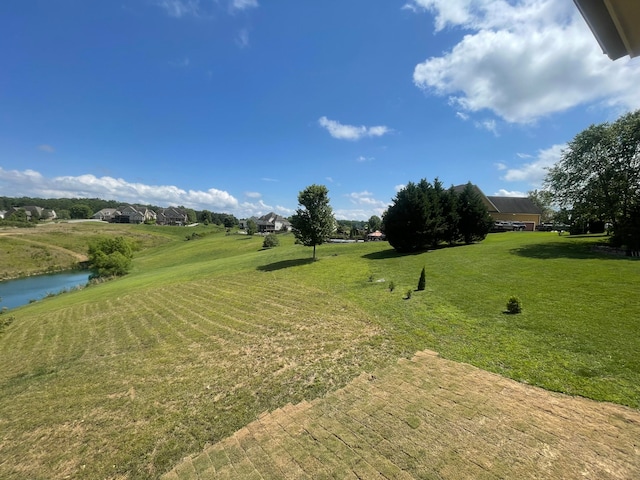 surrounding community featuring a water view and a lawn