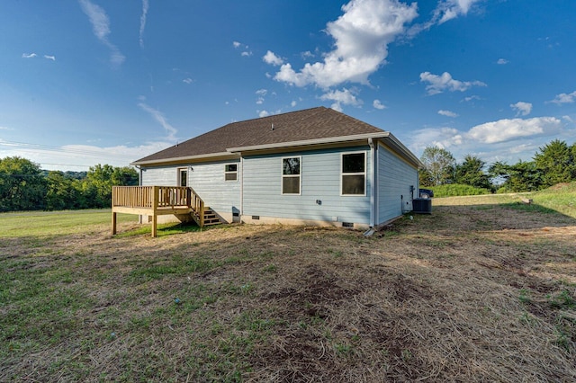 back of property with a wooden deck, cooling unit, and a lawn