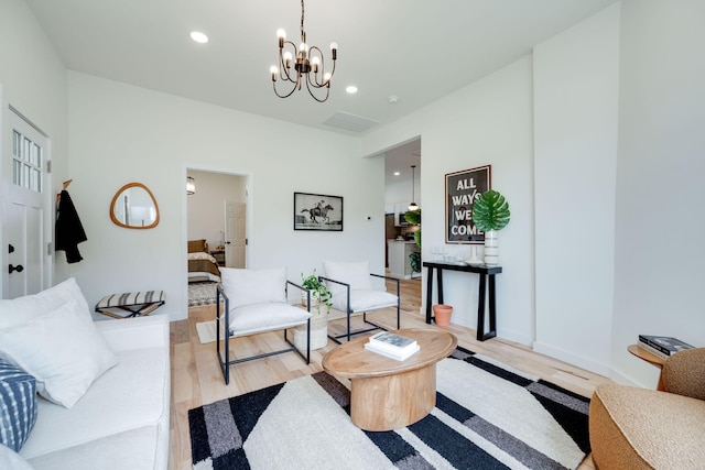 living room featuring a chandelier and light wood-type flooring