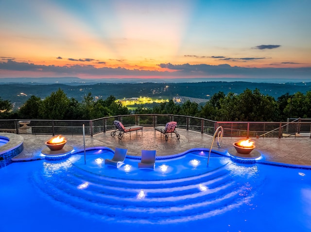 pool at dusk featuring a patio area