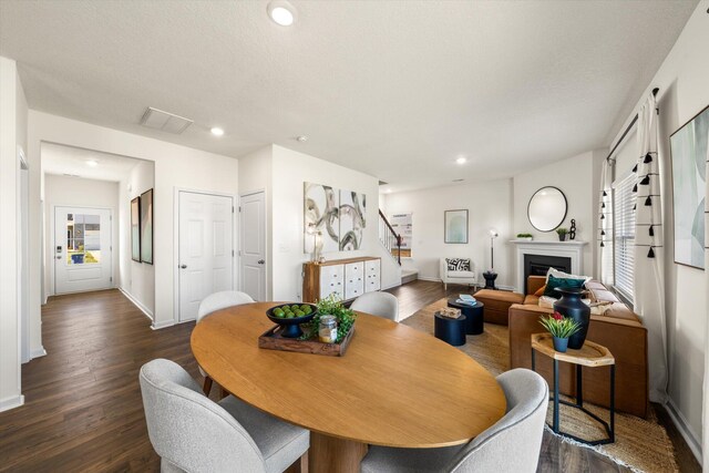 dining space featuring a textured ceiling and dark wood-type flooring