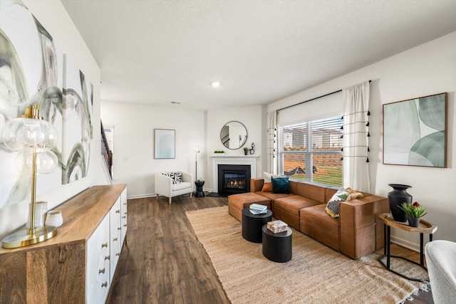 living room featuring dark hardwood / wood-style flooring and a textured ceiling