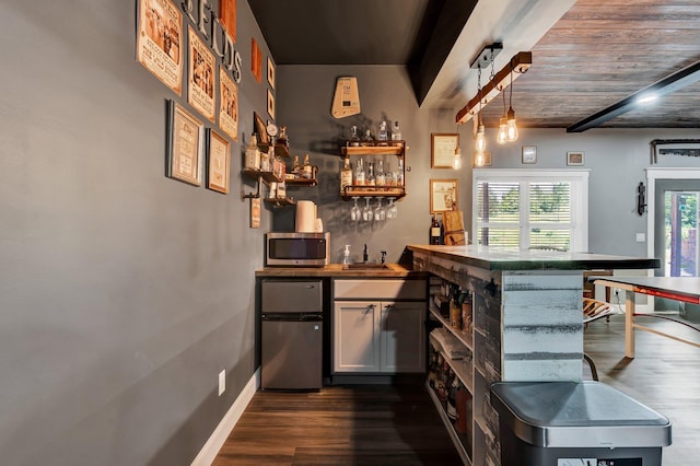 1033 SE Carter Rd, Old Fort, TN 37362 - bar with refrigerator, stainless steel microwave, dark wood-type flooring, beamed ceiling, and indoor wet bar