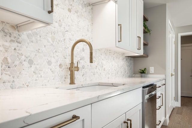 kitchen featuring white cabinetry, wood-type flooring, light stone countertops, and sink