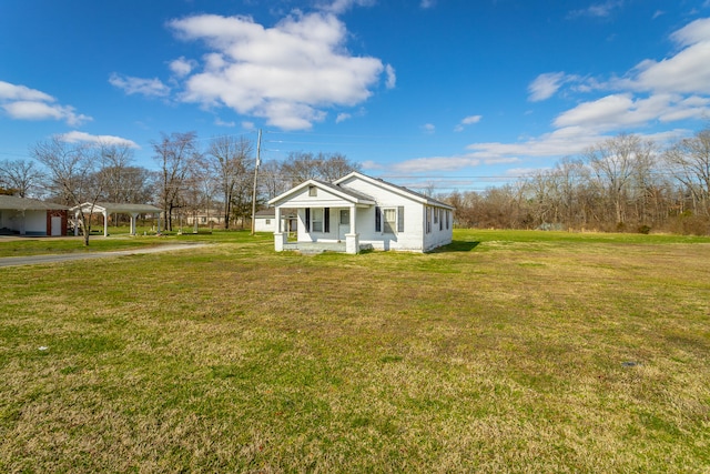 view of side of property with a lawn and covered porch