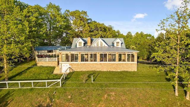 back of house with a sunroom and a yard