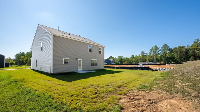 rear view of house with a patio and a yard