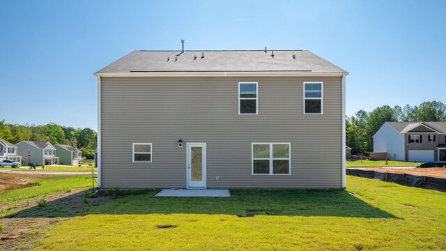 rear view of house featuring a lawn and a patio area