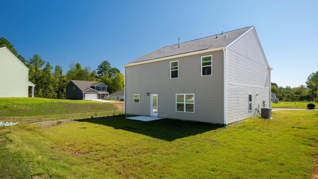 rear view of property with central AC unit, a yard, and a patio