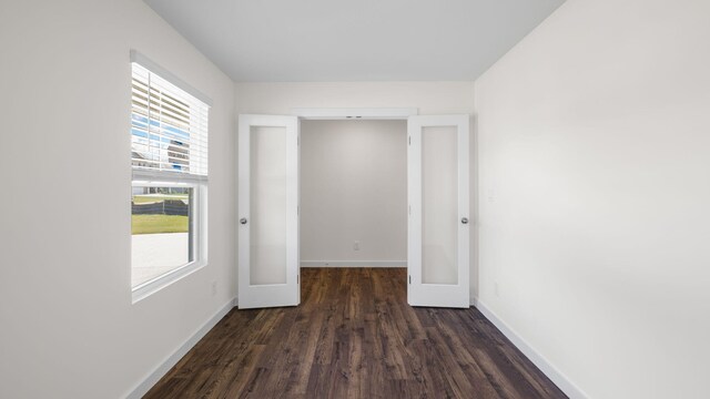 unfurnished room with dark wood-type flooring