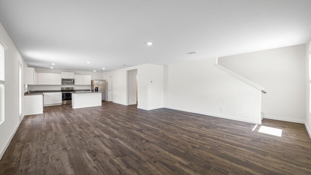 unfurnished living room with dark hardwood / wood-style floors