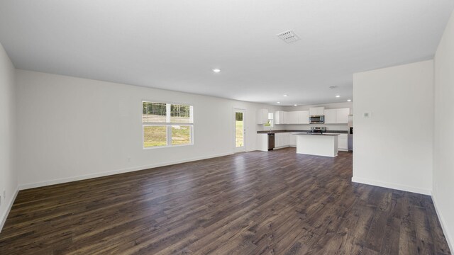 unfurnished living room with dark wood-type flooring