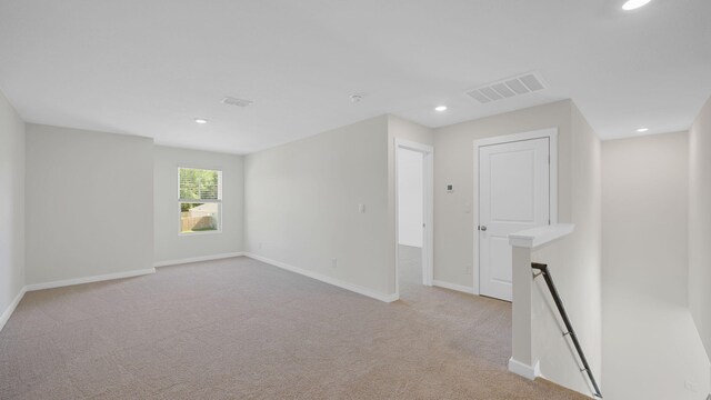 unfurnished room featuring light carpet