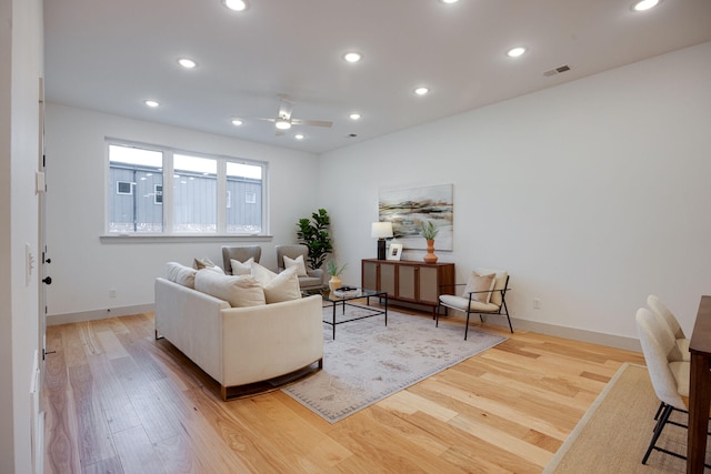 living room with ceiling fan and light hardwood / wood-style flooring