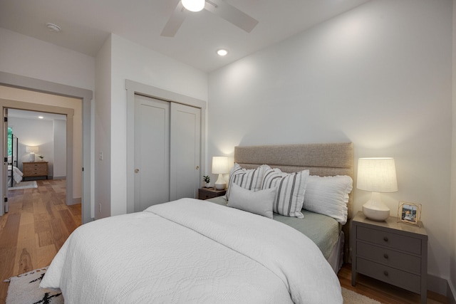 bedroom featuring hardwood / wood-style floors, ceiling fan, and a closet