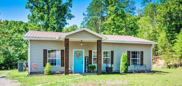 view of front of property featuring a front yard and cooling unit