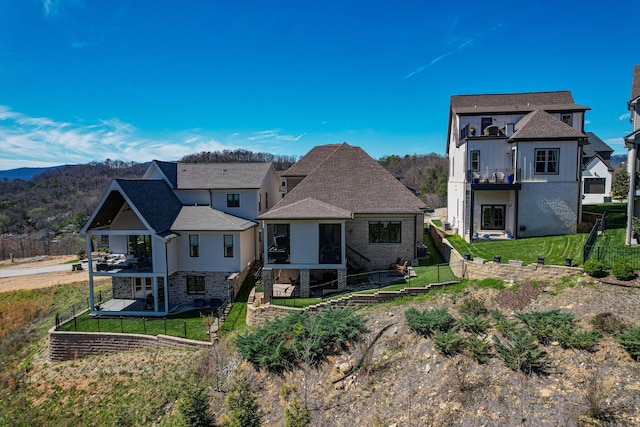 rear view of property featuring a lawn and a balcony