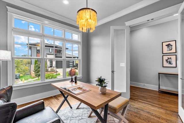 home office with ornamental molding, plenty of natural light, wood-type flooring, and a notable chandelier