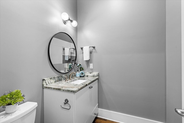 bathroom with hardwood / wood-style flooring, vanity, and toilet