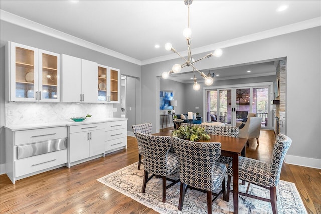 dining area featuring a notable chandelier, light wood-type flooring, and crown molding