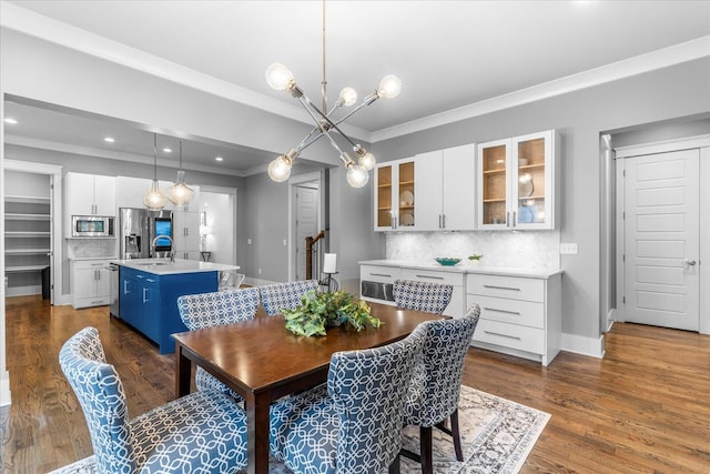 dining room featuring dark hardwood / wood-style flooring, an inviting chandelier, and ornamental molding