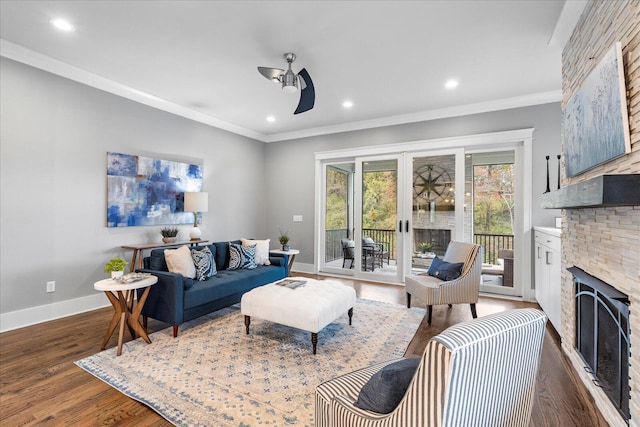 living room featuring ceiling fan, french doors, dark hardwood / wood-style floors, crown molding, and a fireplace