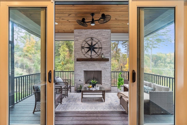 sunroom / solarium featuring an outdoor stone fireplace