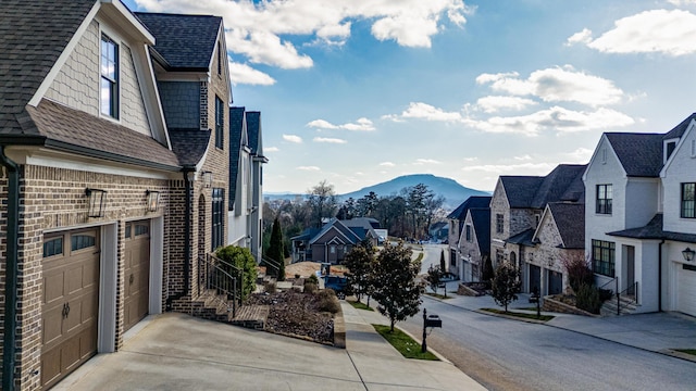 view of street featuring sidewalks, a residential view, a mountain view, and curbs