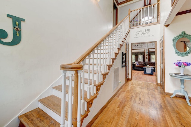 staircase featuring a high ceiling and hardwood / wood-style flooring