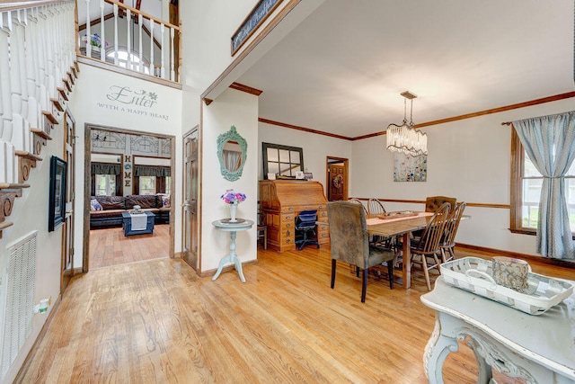 dining room featuring light hardwood / wood-style floors, crown molding, and a chandelier