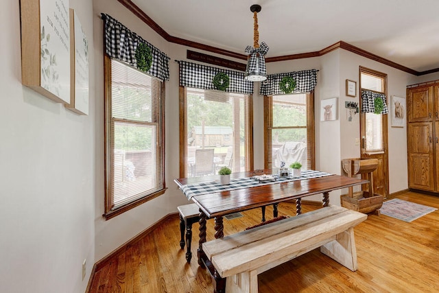 dining space featuring hardwood / wood-style flooring and crown molding