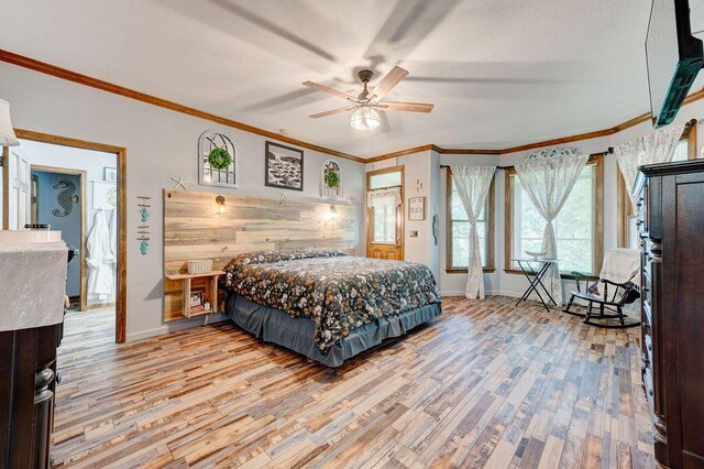 bedroom with ceiling fan, hardwood / wood-style floors, a textured ceiling, and ornamental molding