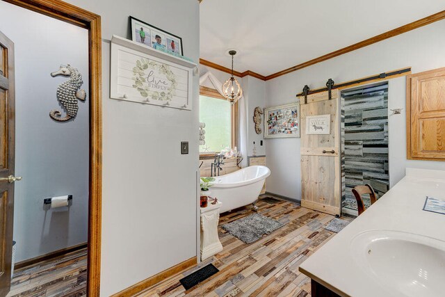 bathroom featuring hardwood / wood-style floors, vanity, a bathtub, and ornamental molding