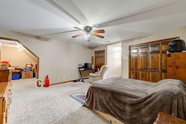 bedroom featuring carpet flooring, a textured ceiling, and ceiling fan