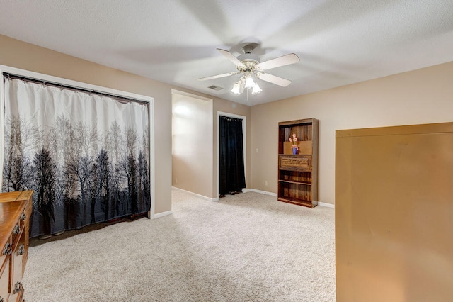 unfurnished bedroom with ceiling fan and light colored carpet