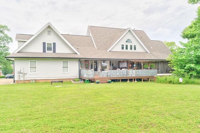 back of property with a sunroom and a lawn