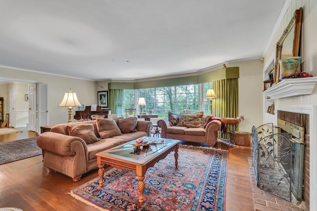 living room featuring crown molding, hardwood / wood-style flooring, and a fireplace