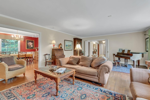 living room with ornamental molding, light hardwood / wood-style flooring, and a notable chandelier