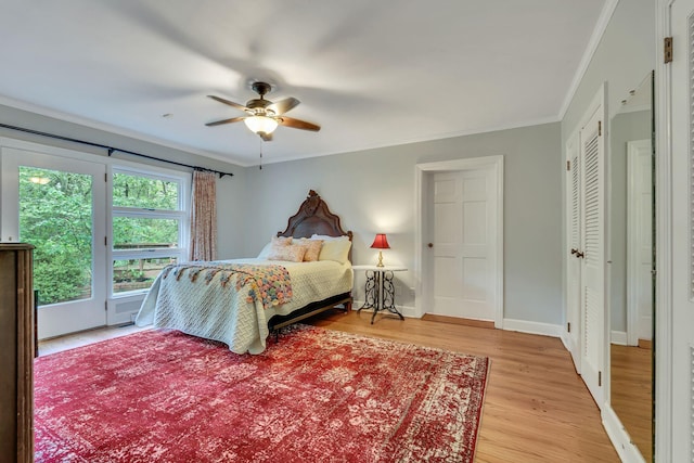 bedroom featuring crown molding, light hardwood / wood-style flooring, and ceiling fan