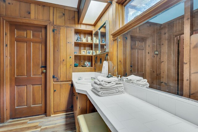 bathroom with vanity, wood walls, and hardwood / wood-style flooring