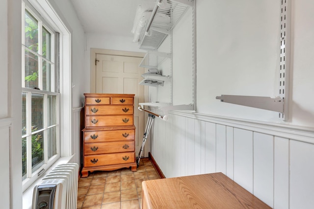 spacious closet featuring light tile patterned floors and radiator