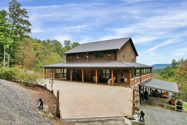 rear view of property featuring a porch and a carport