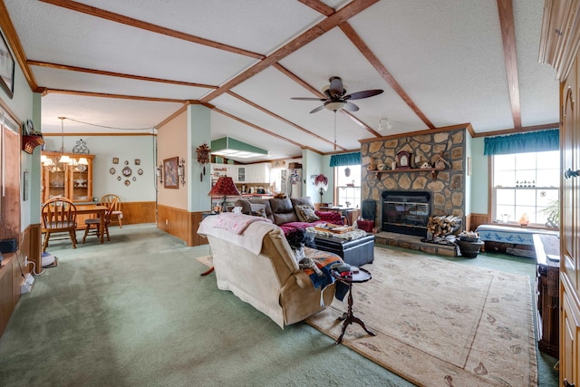 living room featuring a textured ceiling, a healthy amount of sunlight, wood walls, and ceiling fan with notable chandelier