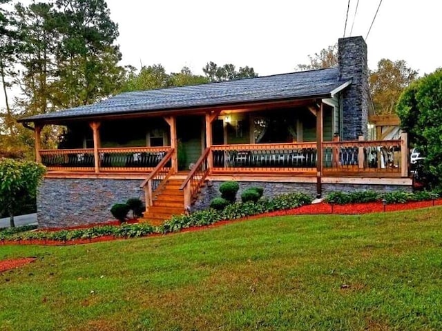 back of property with a yard and a wooden deck