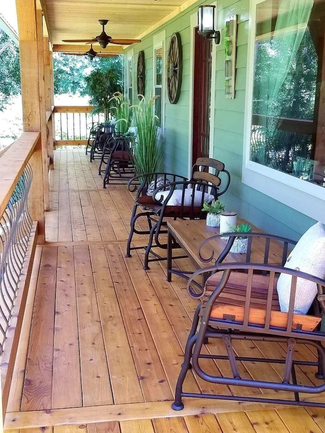 wooden deck featuring a porch and ceiling fan