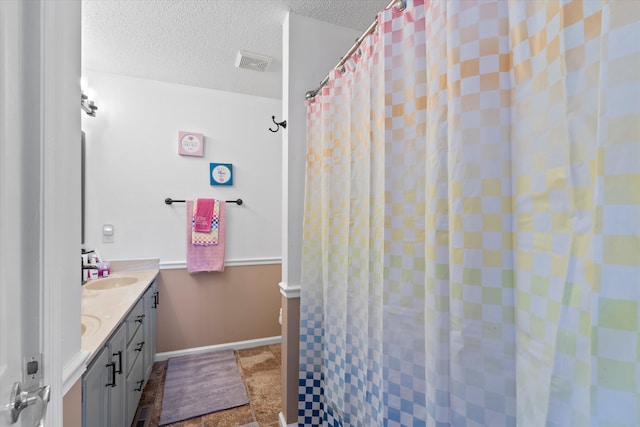 bathroom featuring a shower with shower curtain, a textured ceiling, and vanity