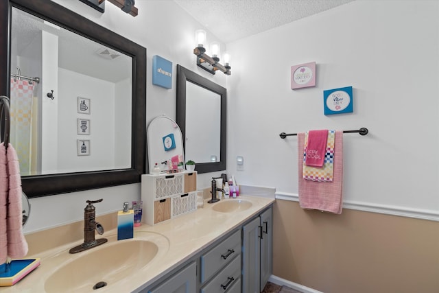 bathroom featuring a textured ceiling, vanity, and curtained shower